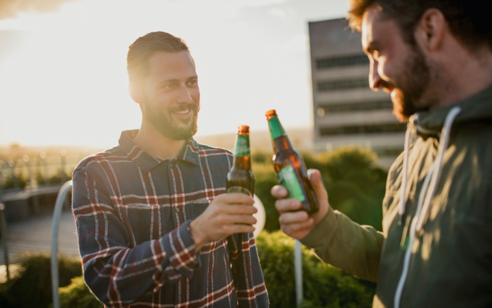 Two males holding beer bottles